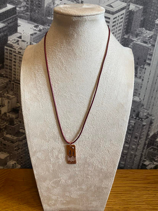 Unusual Long Copper Effect Scene Pendant With A Maroon Coloured Cord